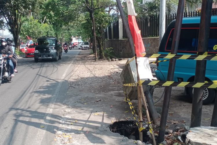 Potret lubang menganga terlihat di Jalan Raya Langsep, Kota Malang, Jawa Timur pada Minggu (15/5/2022).