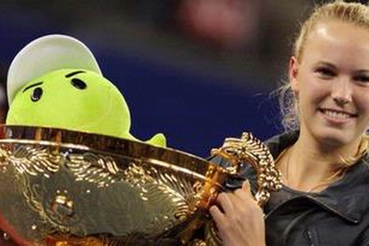 Caroline Wozniacki, mengangkat trofi China Terbuka, setelah kalahkan Vera Zvonareva di final, Senin (11/10/10). Trofi ini lengkapi kesuksesannya sebagai pemain nomor satu dunia.