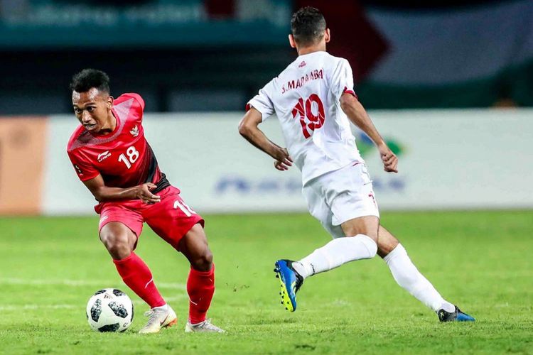 Pemain Timnas U-23 Indonesia, Irfan Jaya, mengecoh pemain Palestina pada pertandingan Grup A Asian Games 2018 di Stadion Patrtiot, 15 Agustus 2018.