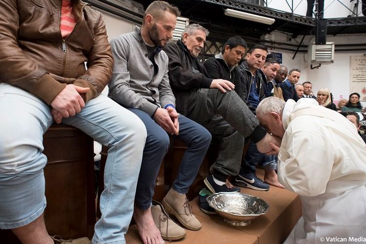 Paus Fransiskus ketika mencium kaki salah satu tahanan dalam ritual pembasuhan kaki, masa sebelum Paskah di Penjara Regina Coeli di Roma, Italia (29/3/2018).