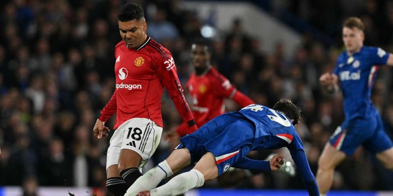 Casemiro (kiri) berduel dengan Alejandro Garnacho (kanan) dalam pertandingan sepak bola Liga Inggris antara Chelsea vs Manchester United di Stamford Bridge di London pada 18 April 2026. (Foto oleh Glyn KIRK / AFP) 