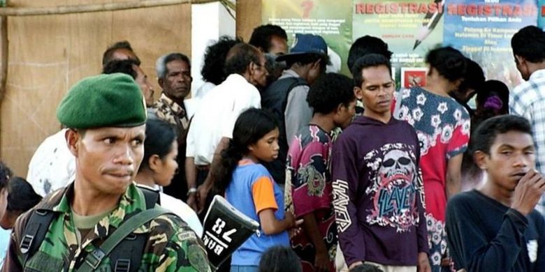 Seorang tentara Indonesia menjaga di kamp pengungsi Kupang sementara pengungsi Timor Timur berkumpul di luar kantor pendaftaran 06 Juni 2001.