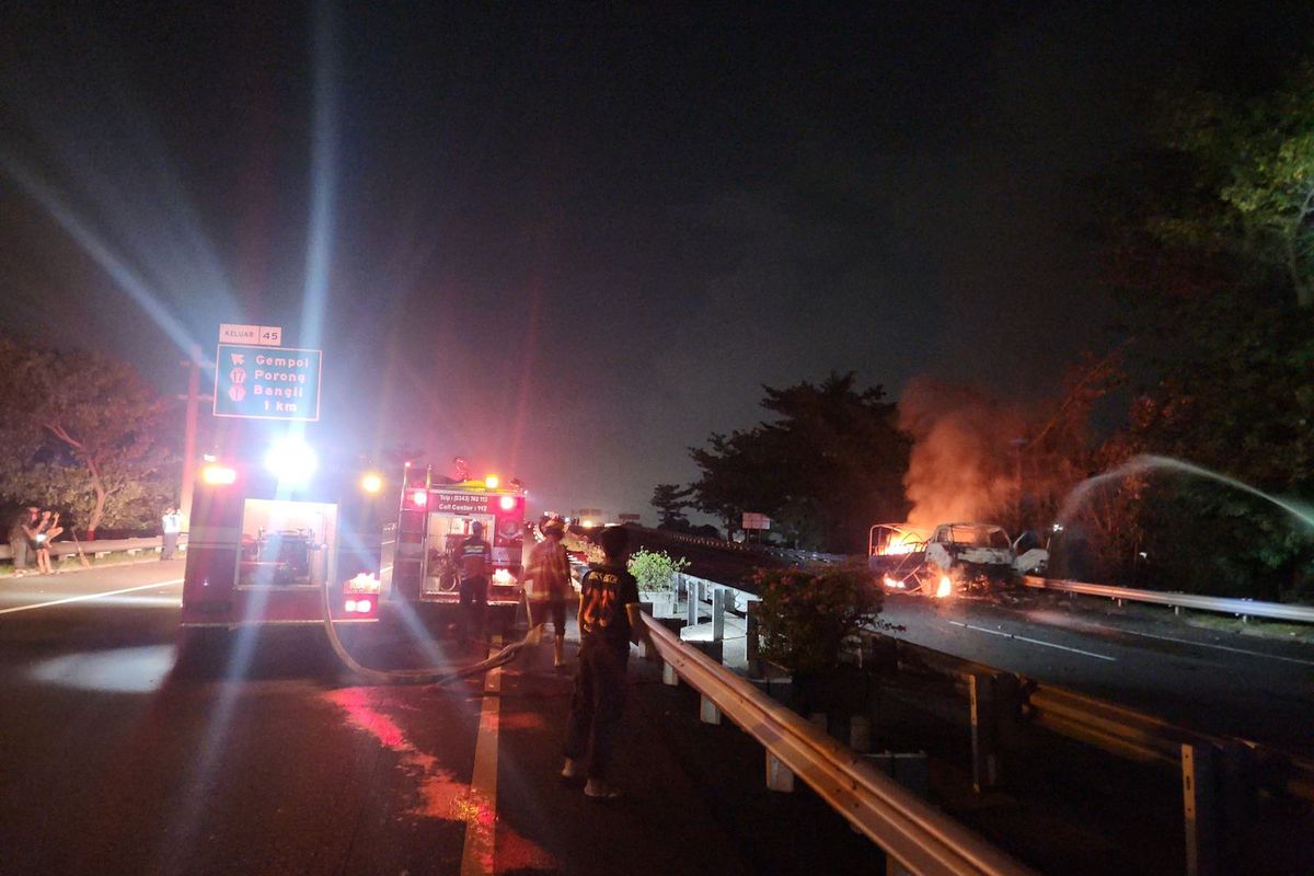 Dua unit kendaraan pemadam kebakaran sedang melakukan pembasahan di lokasi kejadian truk TNI terbakar di ruas Jalan Tol Gempol-Pandaan, Selasa (06/05/2025) 
