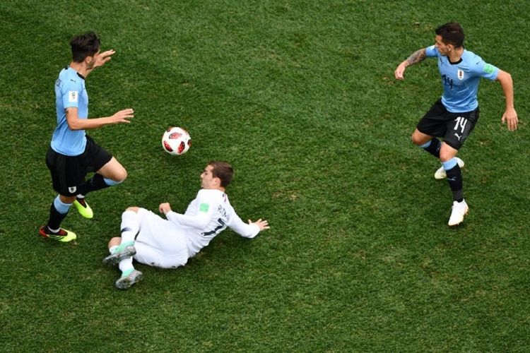 Penyerang Perancis, Antoine Griezmann, dikepung dua pemain Uruguay, Rodrigo Bentancur dan Lucas Torreira, pada pertandingan babak 8 besar atau perempat final Piala Dunia 2018 di Nizhny Novgorod, 6 Juli 2018. 