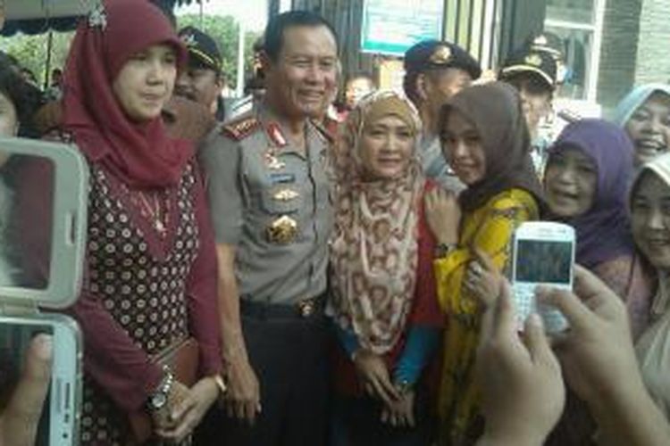 Kepala Polri Jenderal (Pol) Sutarman melayani permintaan berfoto bersama warga Grand Wisata, Tambun, Jawa Barat, Rabu (9/7/2014). Hari ini Sutarman memantau sejumlah tempat pemungutan suara.