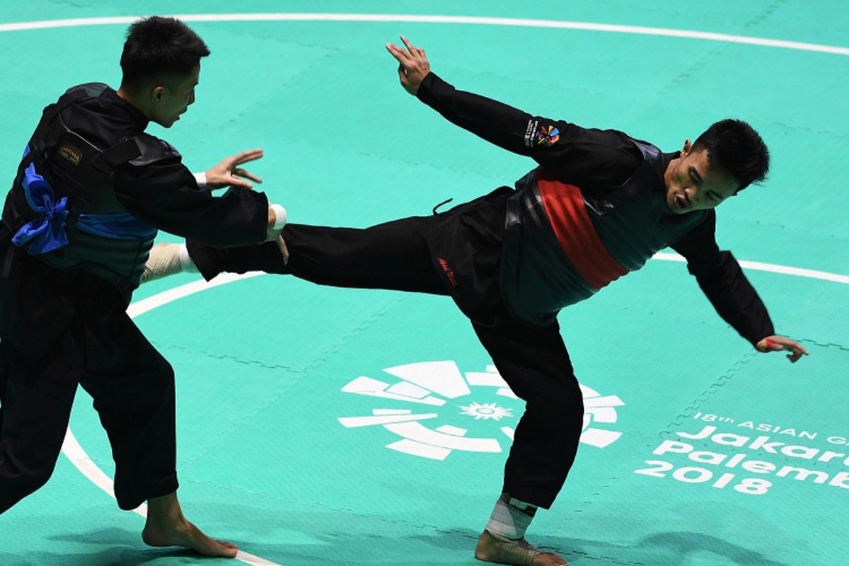 Pesilat Indonesia Abdul Malik (kanan) bertanding melawan pesilat Vietnam Dinh Tuan Nguyen (kiri) dalam babak 16 besar Kelas B Putra Asian Games 2018 di Padepokan Pencak Silat Taman Mini Indonesia Indah (TMII), Jakarta, Kamis (23/8)/2018.  