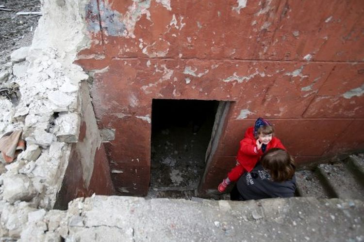 Warga Sievierodonetsk, Oblast Luhansk, melihat keluar dari ruang bawah tanah tempat mereka bersembunyi selama penembakan berat oleh pasukan Rusia dan separatis yang didukung Rusia pada Senin (28/2/2022).