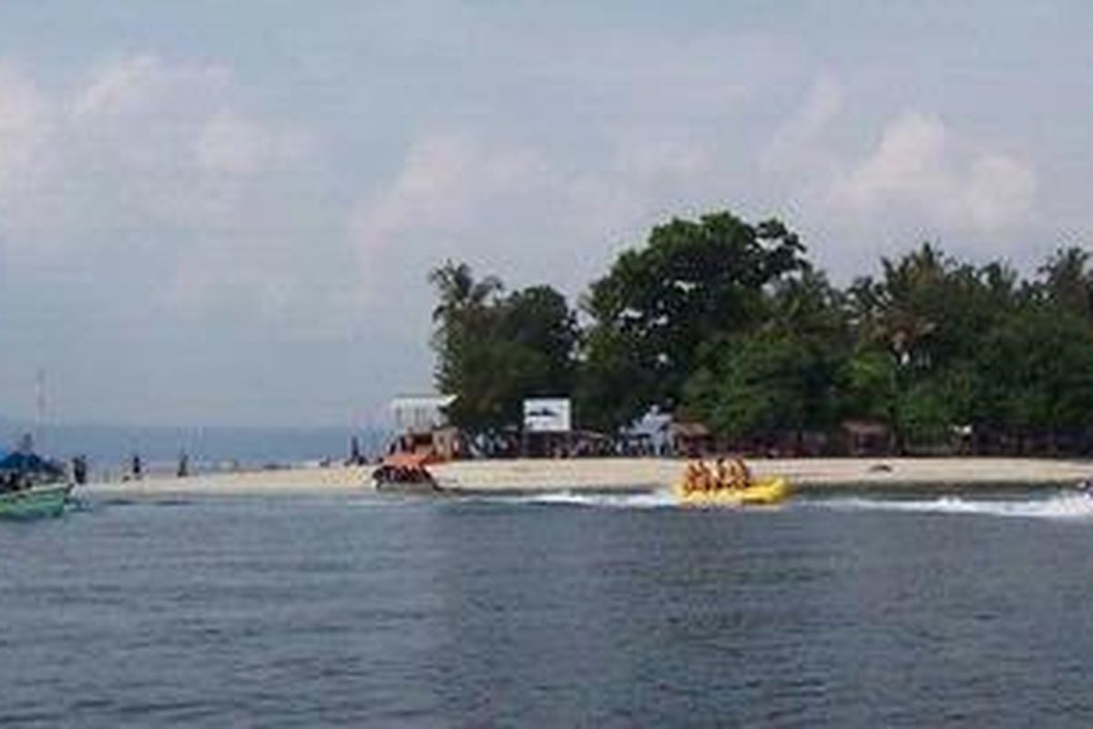 Pemandangan Pulau Tangkil di kawasan perairan Pantai Mutun, Pesawaran, Lampung. Kawasan pantai berpasir putih yang indah ini menjadi daya tarik pariwisata yang banyak menyedot pengunjung terutama di saat libur Lebaran.
