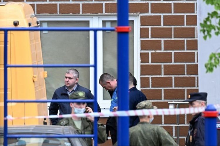 Petugas penegak hukum dan penyelidik terlihat di luar gedung apartemen bertingkat setelah serangan drone yang dilaporkan di Moskwa pada 30 Mei 2023. 