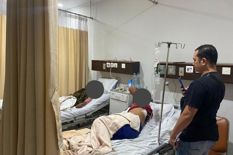 Kondisi tukang parkir berinisial NA (40) dan AG (40) usai dibacok oleh segerombolan pengamen di depan minimarket, Gang Al Huda RT04/05, Kelurahan Pabuaran, Kecamatan Cibinong, Kabupaten Bogor, Jawa Barat.