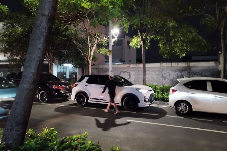 Seorang jukir liar sedang memarkirkan mobil di bahu Jalan Cikini Raya, Menteng, Jakarta Pusat, Jumat (7/7/2023) malam. (KOMPAS.com/XENA OLIVIA)