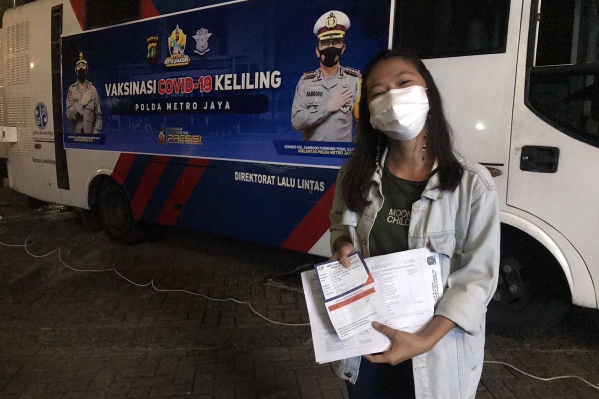 Salah satu warga di sekitar Kemang, Lia (23) mengantre untuk menjalani vaksinasi Covid-19 di dekat perempatan McDonalds Kemang, Bangka, Mampang Prapatan, Jakarta Selatan pada Selasa (29/6/2021) malam.