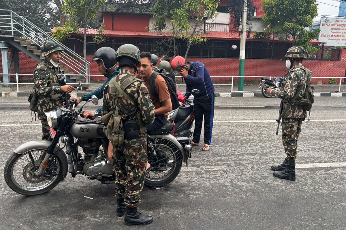 Personel militer memeriksa bukti identitas dan dokumen para komuter di jalan sebagai langkah-langkah keamanan di Kathmandu pada 10 September 2025. Pada demo Nepal, para demonstran membakar gedung parlemen pada 9 September.