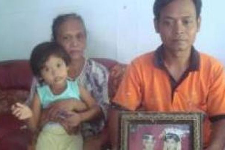 Suprapto (33) warga Dusun Jetak, Desa Bajang, Kecamatan Mlarak, Kabupaten Ponorogo menunjukkan foto istrinya yang diduga jari kirinya dipotong majikannya di Hongkong, Jumat (28/2/2014).