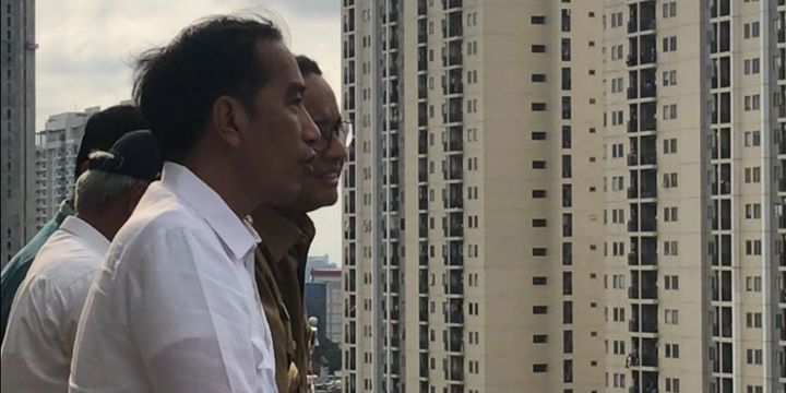 Presiden Joko Widodo dan Gubernur DKI Jakarta Anies Baswedan sedang berbincang di sela peninjauan pembangunan Wisma Atlet Kemayoran, Jakarta Pusat, Senin (26/2/2018).