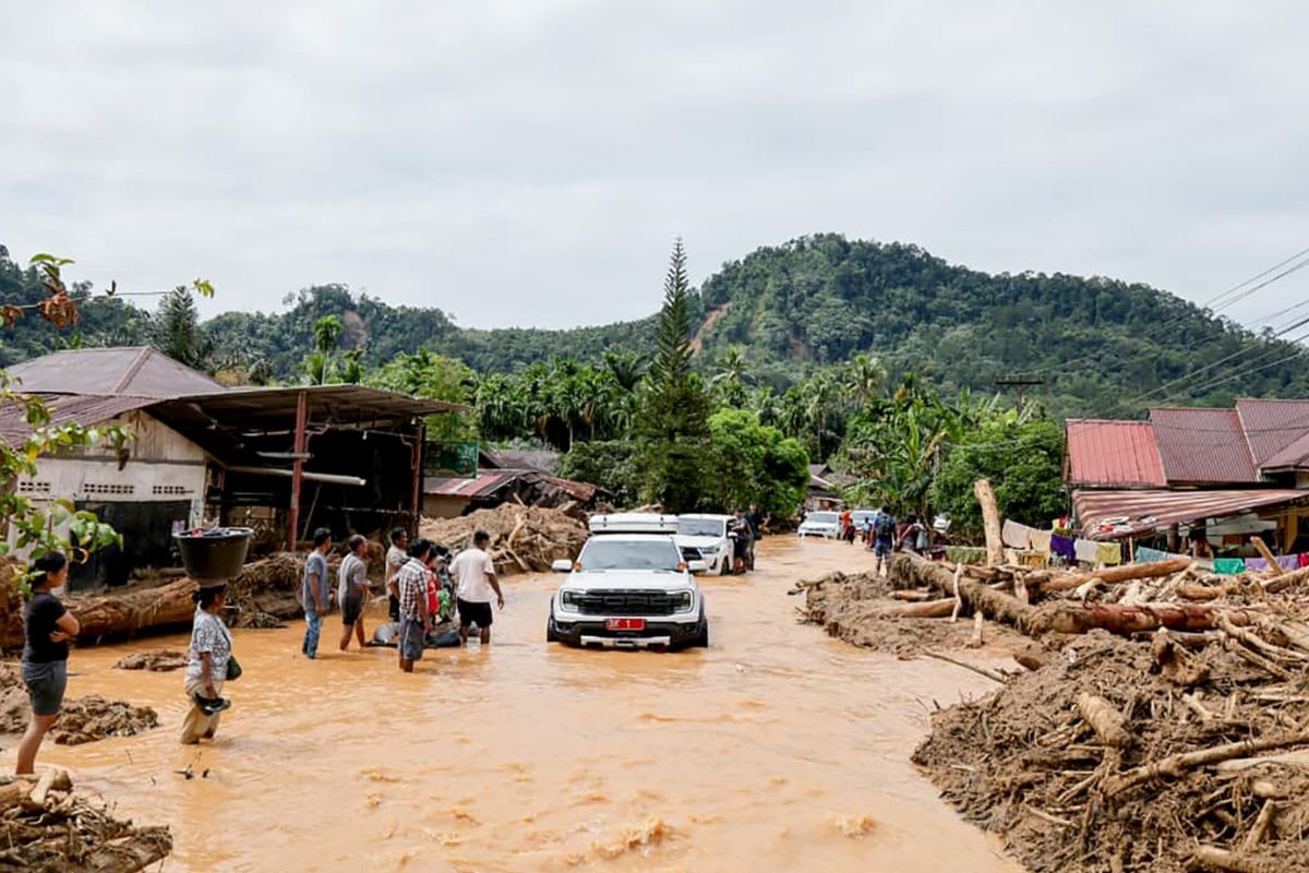 Mobil Gubenur Sumatera Utara (Sumut) Bobby Nasution saat menembus akses jalan yang terdampak banjir di Kecamatan Tukka, Kabupaten Tapanuli Tengah, Selasa (2/12/2025). 
