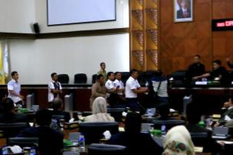 Anggota DPR Aceh, Ridwan Abubakar dilerai oleh petugas keamanan sesaat melempar kertas ke arah ketua DPR Aceh saat sidang penetapan ketua Definitif DPR Aceh, Selasa (9/12/2014).