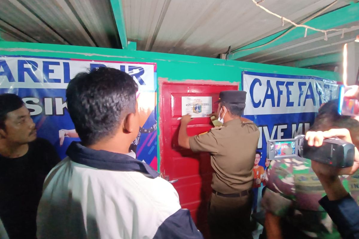 Satpol PP Jakarta Timur menyegel kafe remang-remang bernama Cafe Farel BJR karena tempat izin usahanya tidak sesuai di Jalan Sejajar Sisi Tol Timur, Pulogebang, Cakung, Kamis (23/11/2023) malam.