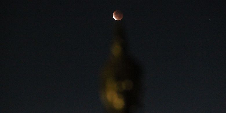 Gerhana bulan total dengan latar depan patung Budha di Vihara Hemadhiro Mettavati, Cengkareng, Jakarta Barat, Rabu (26/5/2021). Gerhana Bulan Total tanggal 26 Mei 2021 ini dikenal juga dengan Super Blood Moon (Bulan Merah Super), karena terjadi saat bulan di di jarak terdekat dengan Bumi (Perigee).