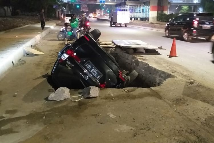 Mobil Xenia B 1249 UIY terperosok ke dalam lubanh galian di Jalan DI Panjaitan, Jakarta Timur, Senin (25/11/2019) pagi.