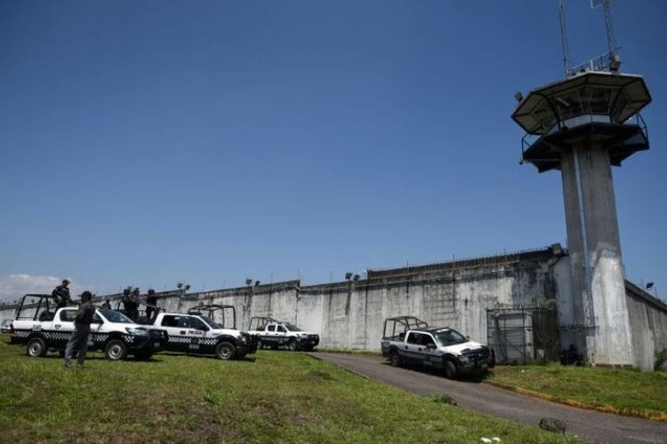 Polisi menjaga pintu masuk penjara La Toma usai dilanda yang menyebabkan sejumlah polisi tewas di Amatlan de los Reyes, Veracruz, Meksiko, Minggu (1/4/2018). (AFP/Victoria Razo)