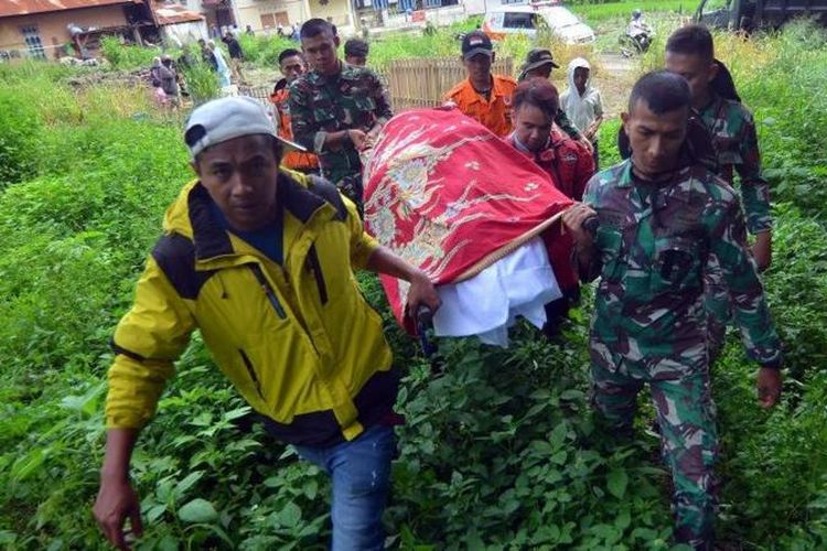 Relawan bencana bersama prajurit TNI dan warga menggotong jenazah korban banjir bandang yang baru ditemukan di Jorong Galuang, Nagari Sungai Pua, Agam, Sumatera Barat, Selasa (14/5/2024).