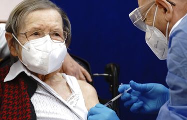 Ruth Heller yang berusia 100 tahun, kiri, divaksinasi terhadap virus Corona oleh pemberi vaksin Fatmir Dalladaku di panti jompo Agaplesion Bethanien Sophienhaus di Berlin, Jerman, pada Minggu (27/12/2020). 