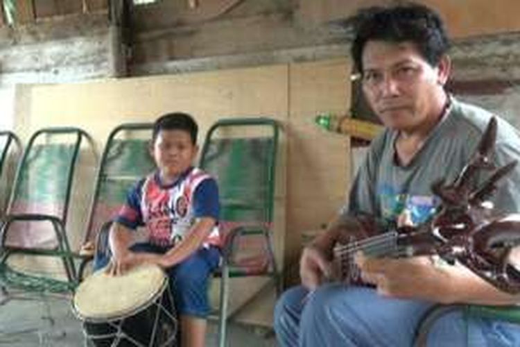 Kusyadi bermain musik gambus ditemani salah satu anaknya.