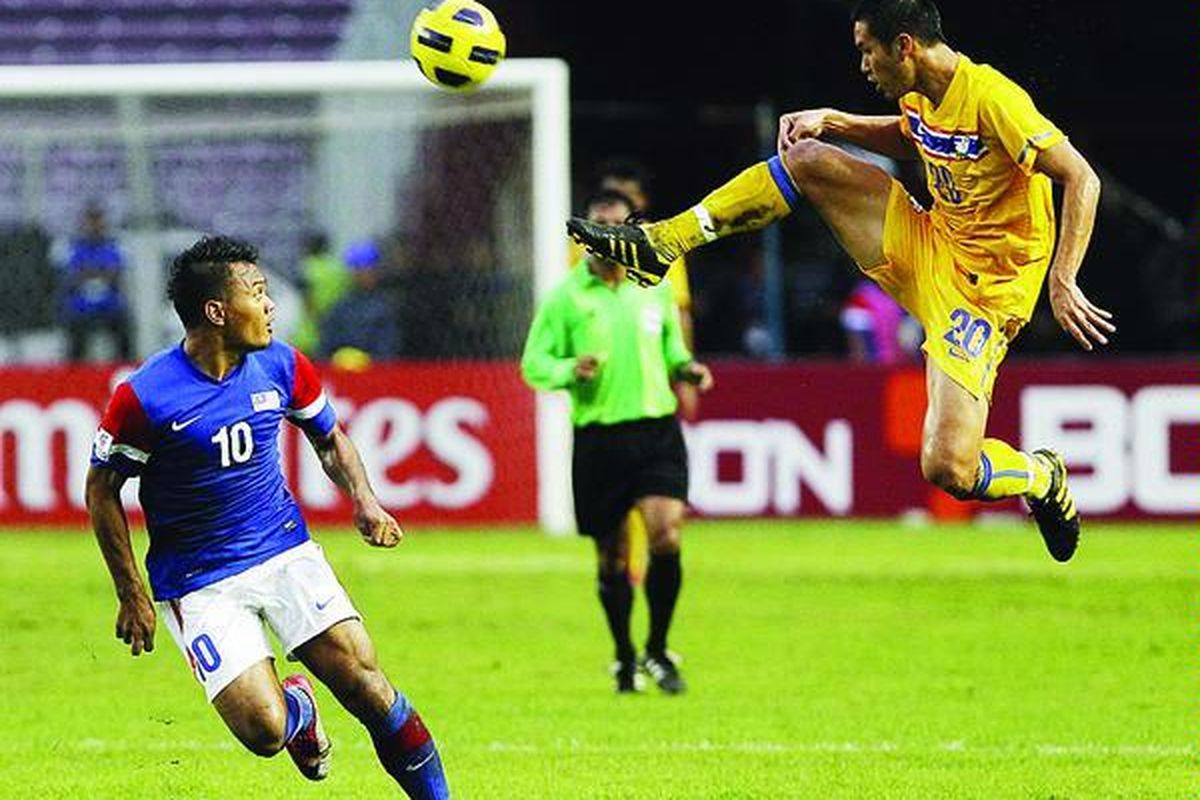 Pemain Thailand, Panupong Wongsa (kanan), menghalau bola di depan pemain Malaysia, Mohd Safee bin Mohd Sali, dalam Piala Suzuki AFF 2010 di Stadion Utama Gelora Bung Karno, Sabtu (4/12). Pertandingan berakhir seri 0-0.