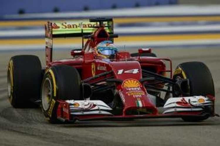 Pebalap Scuderia Ferrari asal Spanyol, Fernando Alonso, membalap di Sirkuit Marina Bay Street pada sesi latihan pertama GP Singapura, Jumat (19/9/2014).