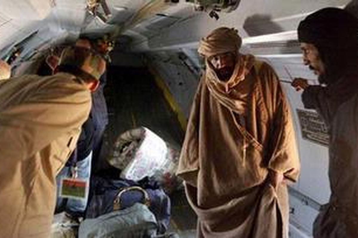 Saif Khadafy (kedua dari kanan) dalam pesawat yang membawanya ke Zintan, menyusul penangkapannya di padang gurun di Libya selatan, sabtu (19/11/2011).