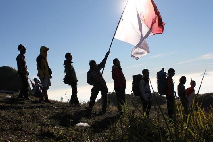 Para pemuda menikmati pemandangan dari atas Gunung Prau, Dieng, Jawa Tengah