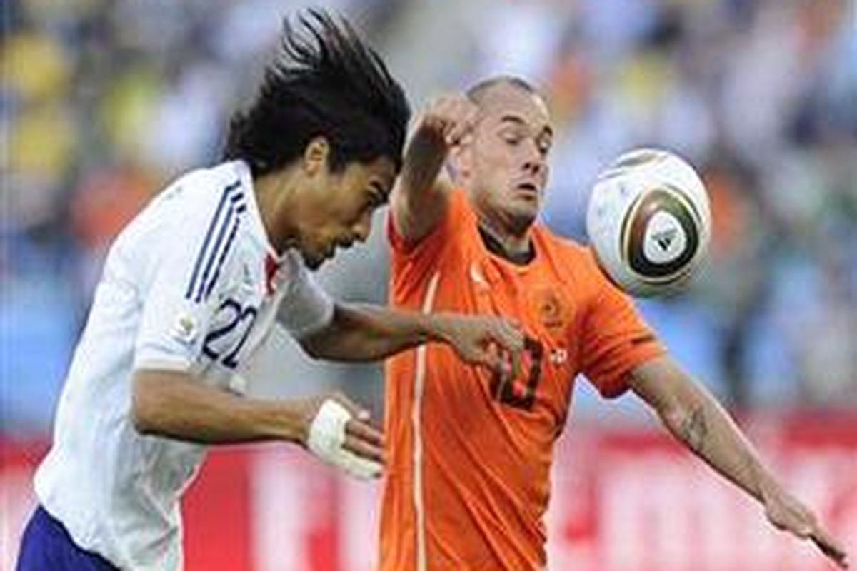Pemain Jepang Yuji Nakazawa (kiri) berebut bola dengan gelandang Belandan Wesley Sneijder dalam duel penyisihan Grup E Piala Dunia 2010 di Stadion Moses Mabhida, Durban, Sabtu (19/6/2010).