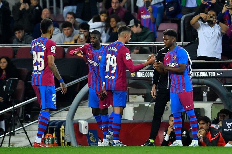 Penyerang Barcelona Ousmane Dembele (2L) dan Ansu Fati (kanan) bersiap untuk turun lapangan melawan RCD Mallorca di Stadion Camp Nou, pada Senin (2/5/2022) dini hari WIB. 