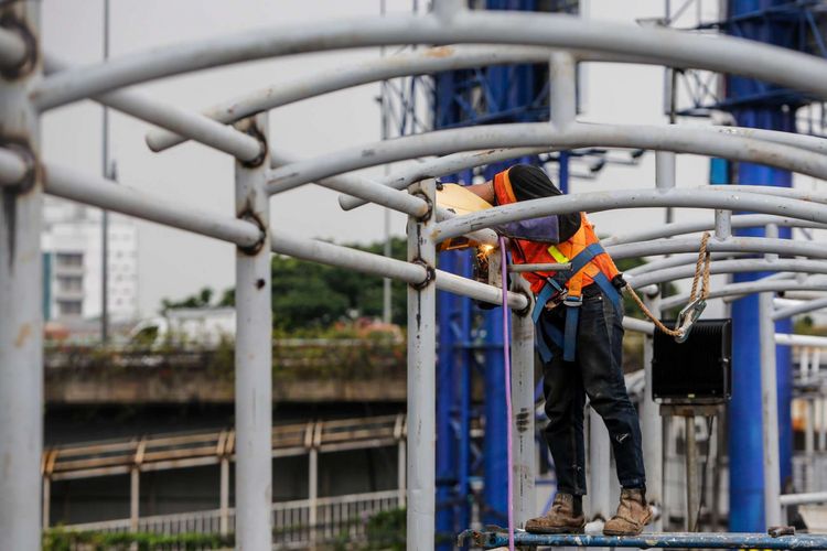 Pekerja menyelesaikan pembangunan Jembatan Penyebrangan Orang (JPO) di Halte Kuningan Timur, Jakarta Selatan, Rabu (17/1/2018). Pembangunan JPO tersebut sebagai akses warga untuk naik Bus Transjakarta yang terkena dampak pembangunan LRT.