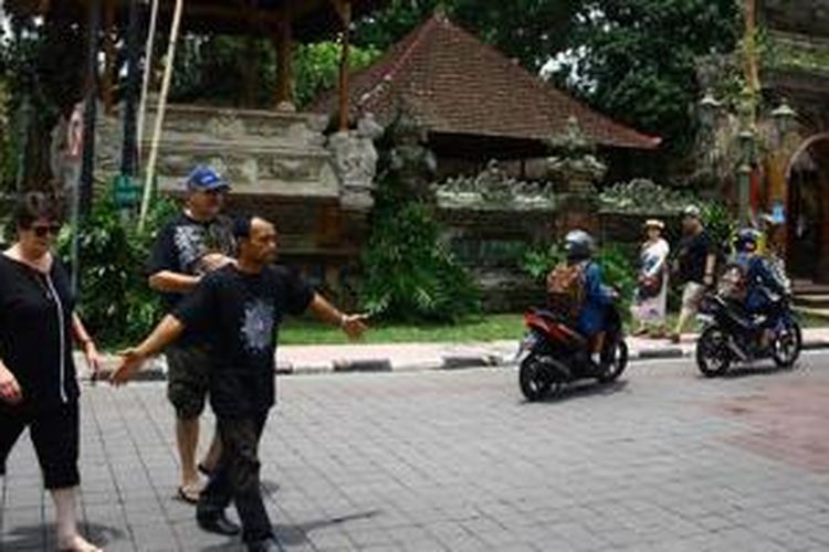 Seorang pemandu wisata membawa turis berkeliling Ubud, Gianyar, Bali.