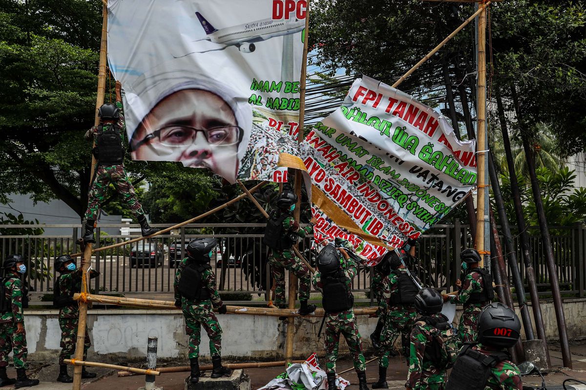 Prajurit TNI menertibkan spanduk tidak berizin saat patroli keamanan di Tanah Abang, Jakarta Pusat, Jumat (20/11/2020). Pangdam Jaya Mayjen TNI Dudung Abdurachman, memerintahkan jajarannya untuk mencopot spanduk dan baliho pemimpin Front Pembela Islam (FPI) Rizieq Shihab.