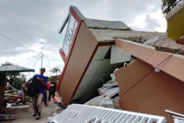 Seorang warga di Desa Cibulakan, Cugenang, Cianjur, Jawa Barat, melintas di antara reruntuhan bangunan rumah yang ambruk diguncang gempa magnitudo 5,6.