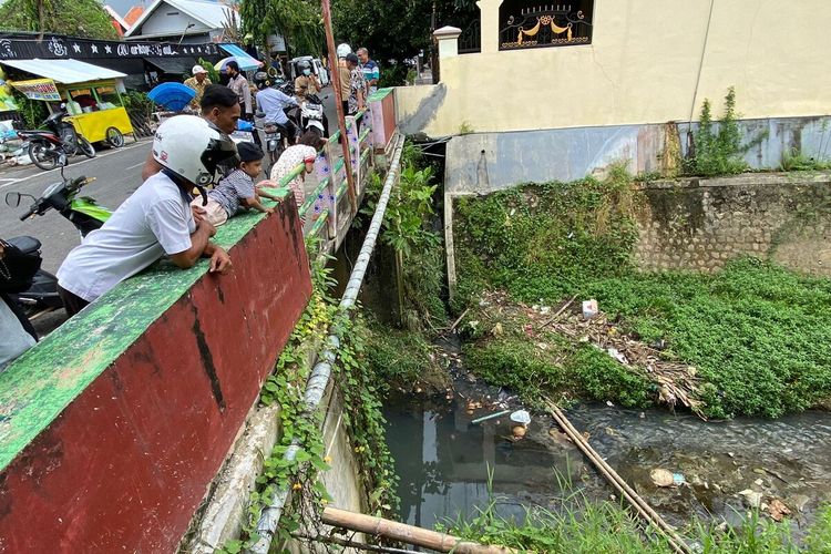 Warga melihat lokasi penemuan bayi tanpa kepala di Jl. Cokroatmojo Kelurahan Parteker, Kecamatan Pamekasan Kamis (10/2/2022).