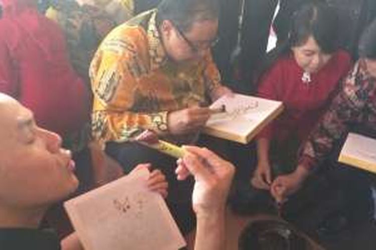 Menteri Koperasi dan UMKM Anak Agung Gede Puspayoga membatik ditemani Gubernur Jawa Tengah dan Kepala Badan Ekonomi Kreatif RI di Pekan Batik Nusantara 2016 di Lapangan Jetayu Kota Pekalongan.