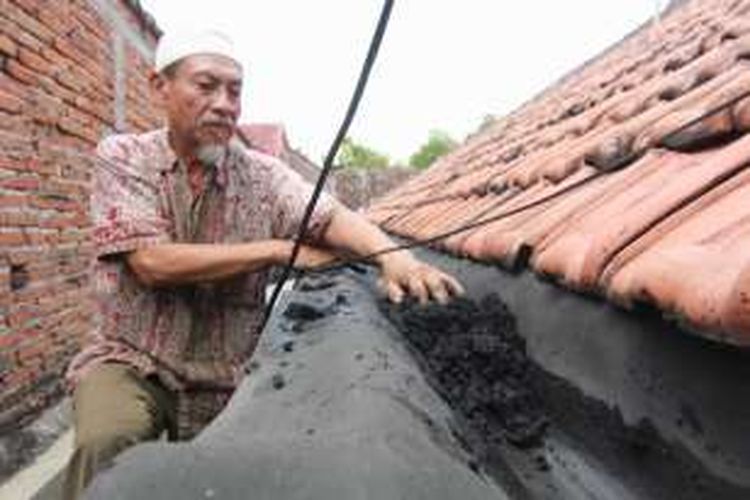 Mulyadi, warga Manisrejo, Kecamatan Karang Rejo, Kabupaten Magetan, Jawa Timur, mengeruk tumpukan abu yang berasal dari cerobong asap Pabrik Gula Purwodadi Magetan, Rabu (7/9/2016) siang. 