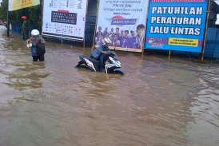 Salah seorang pengendara motor saat mendorong motornya yang mogok saat banjir Gedebage, Jum'at (28/10/2016) siang.