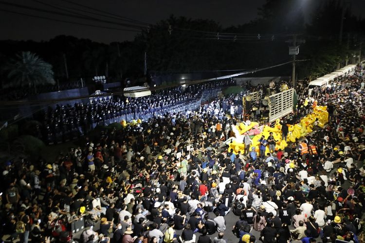 Polisi anti-huruhara berjaga saat demonstran menggelar unjuk rasa di luar markas Resimen Infantri ke-11, unit keamanan istana di bawah komando langsung Raja Thailand, Minggu (29/11/2020). Para pengunjuk rasa pro-demokrasi melanjutkan aksi protes mereka yang telah berlangsung selama berbulan-bulan.