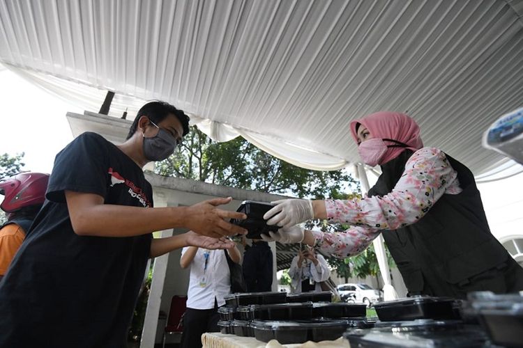 Ketua Umum Jabar Bergerak Atalia Ridwan Kamil, membagikan nasi kotak dan air mineral kepada warga yang membutuhkan dan pengemudi ojek online (ojol), di Pintu Barat Gedung Pakuan Bandung, Senin (13/4/2020).