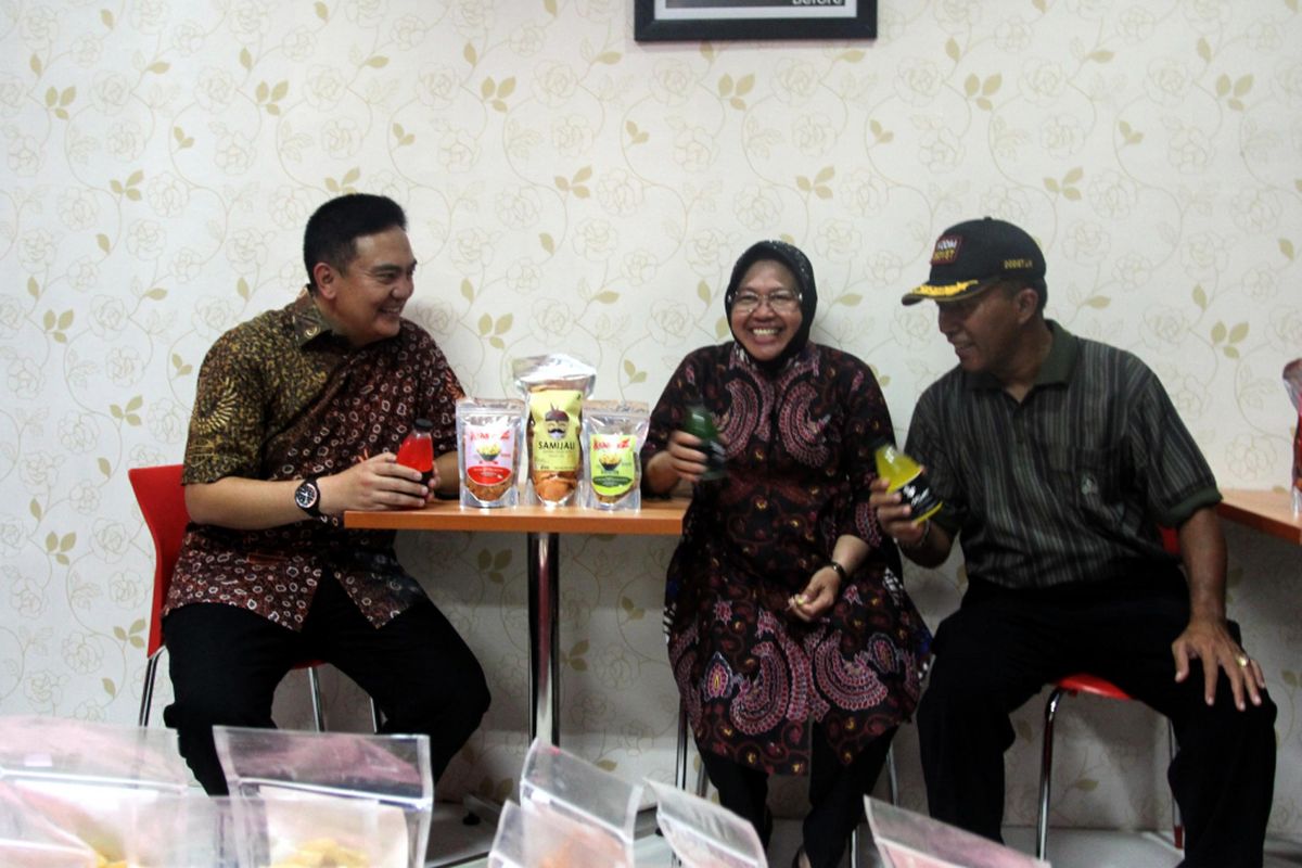 Wali kota Surabaya, Tri Rismaharini (tengah) memamerkan produk buatan warga Dolly