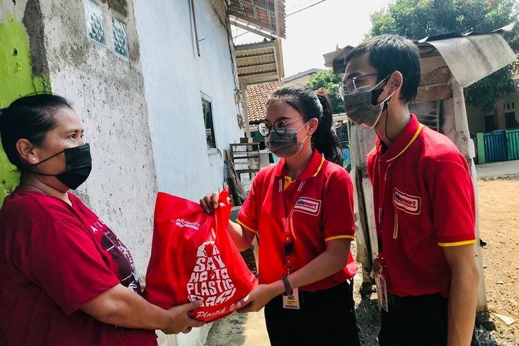 Karyawan Alfamart saat memberikan bantuan kepada masyarakat