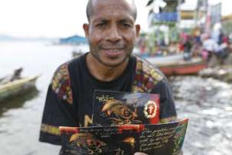 Thomas Maay dengan karyanya ukiran indah di atas kertas foto yang terbakar saat ditemui di Festival Danau Sentani, Kabupaten jayapura, Papua, Senin (20/6/2016).