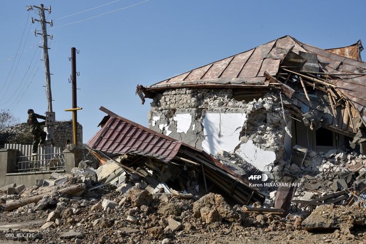 Seorang pria memperbaiki kabel yang rusak di sebelah puing-puing rumah di kota bersejarah Shusha, sekitar 15 kilometer dari ibu kota wilayah sengketa Nagorno-Karabakh Stepanakert, pada 1 November 2020.
