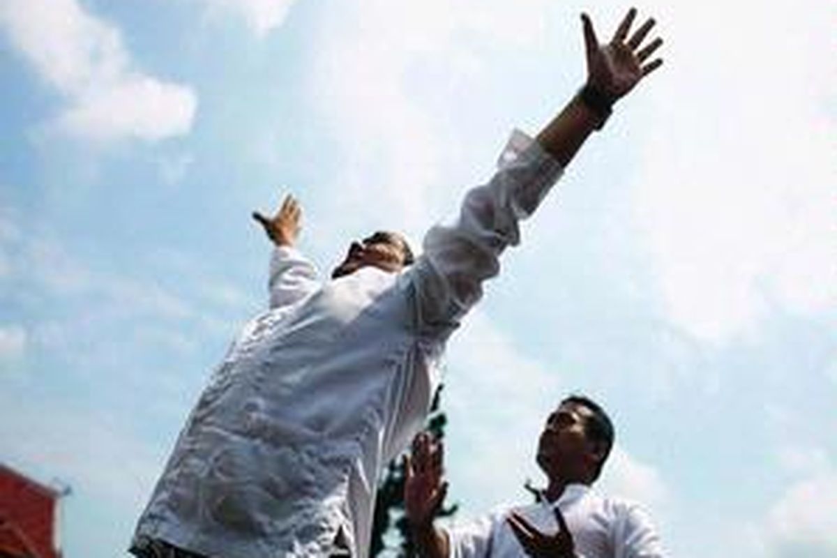 Akie, seorang pawang hujan, memeragakan cara memindahkan awan dibantu oleh Taufik.