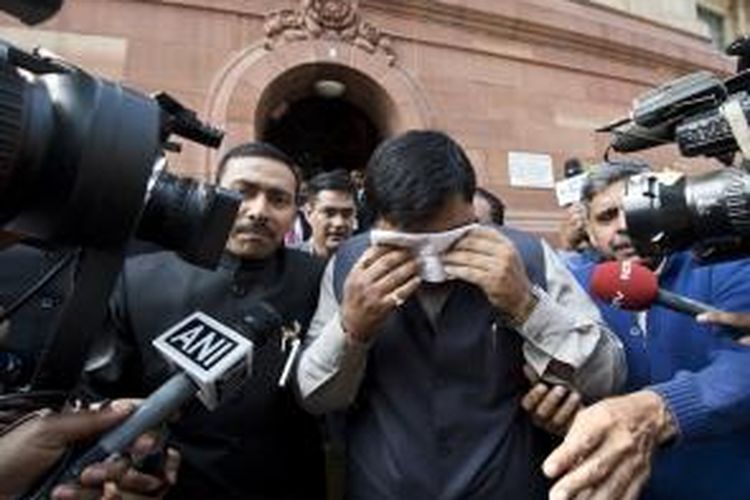Seorang anggota parlemen India menutupi wajahnya yang terkena dampak semprotan merica dalam keributan di parlemen yang dipicu perbedaan pendapat soal pembentukan negara bagian baru.